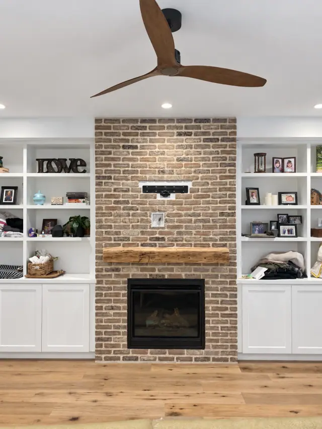 Brick fireplace surround and timber mantel between white built-in shelves