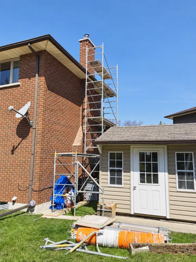 Brick chimney with scaffolding erected alongside the house during the rebuild project